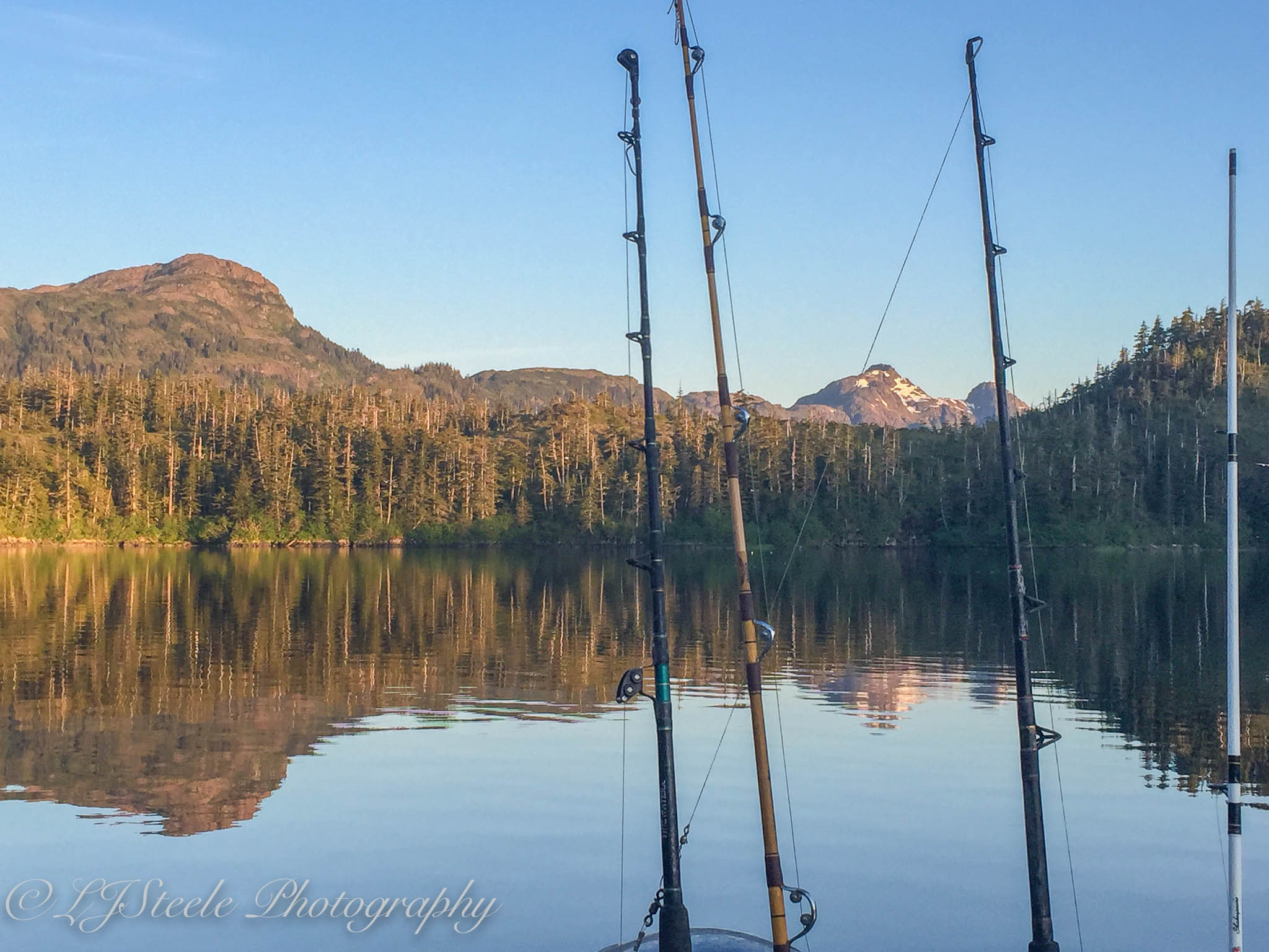 Fishing rods by a serene mountain lake.