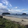 Sandy beach with distant islands and clouds.
